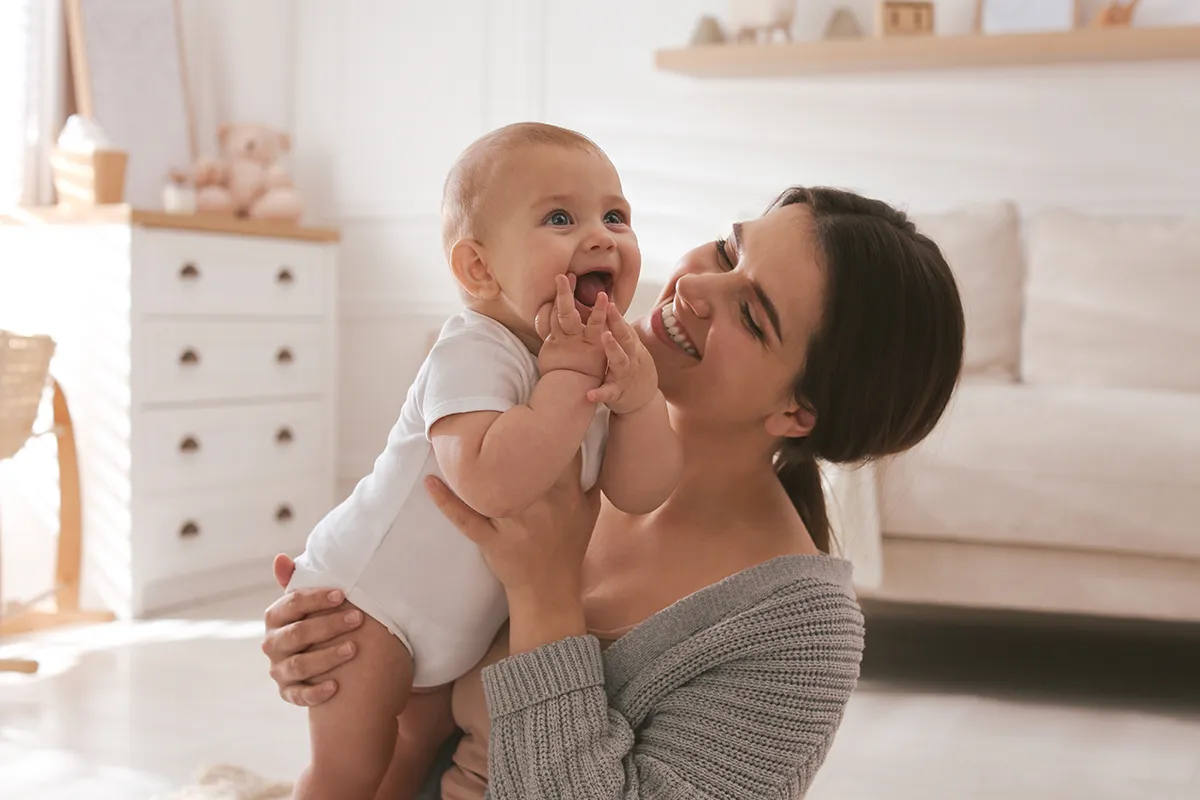 a young mother with her smiling baby at home