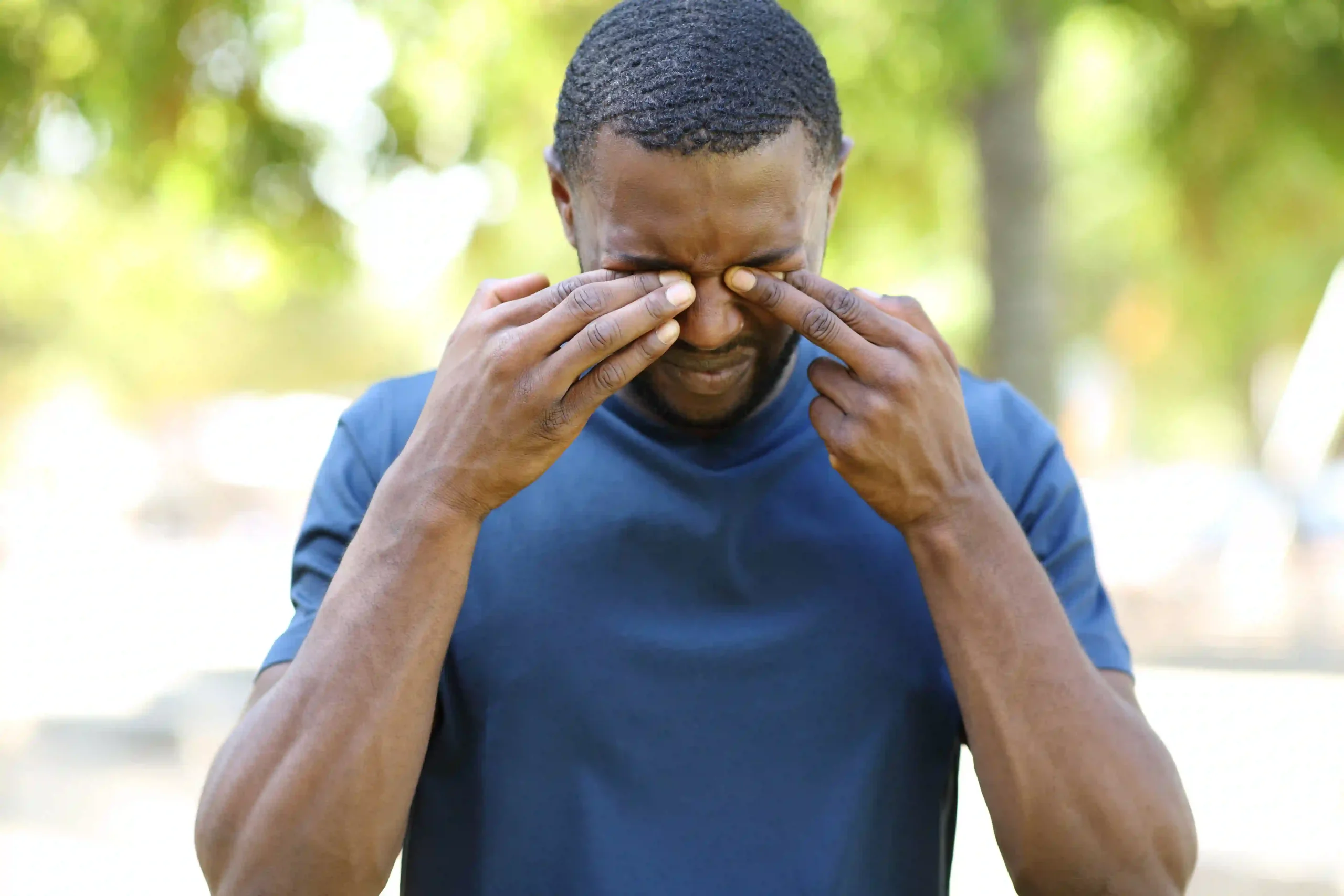 man rubbing stinging eyes